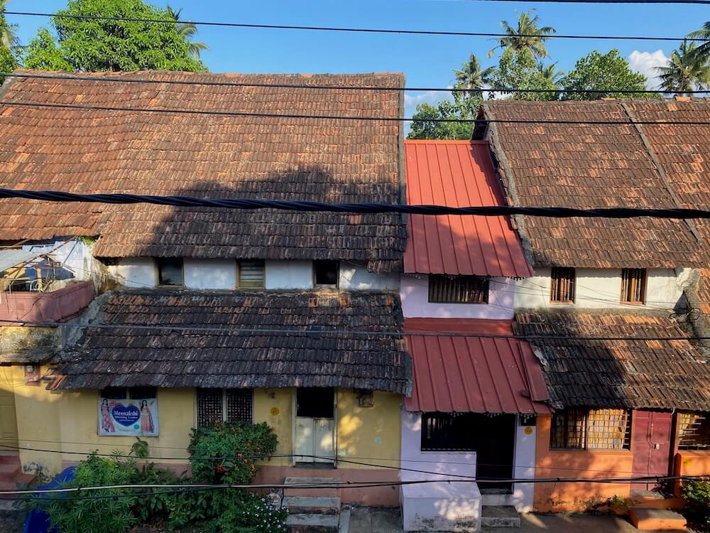 A street of colorful traditional homes with long slanting ceramic tile roofs.