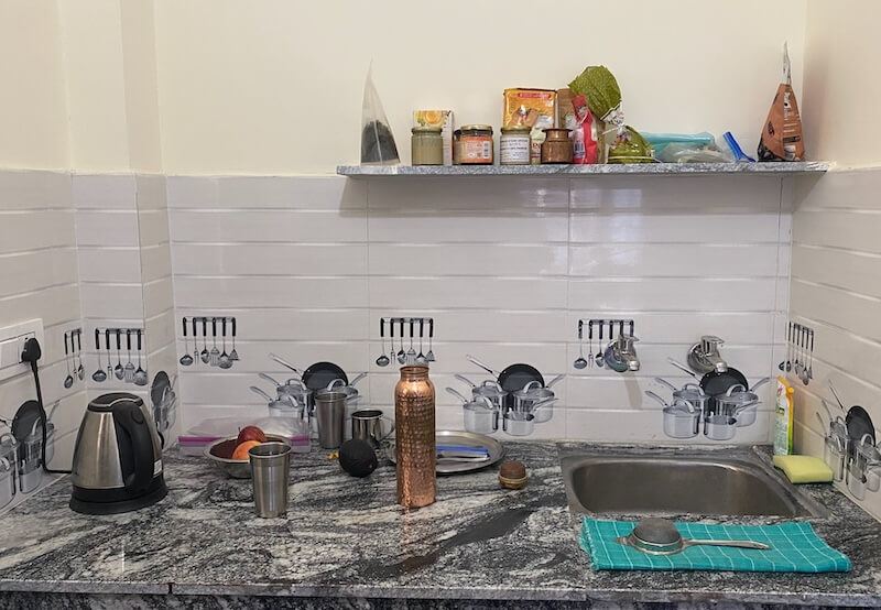 A kitchen countertop with a few food items, a sink and an electric kettle.