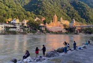 Ganga river with people relaxing and temple in the background.